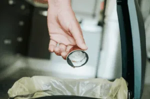 Mano getta coperchio nel cestino
