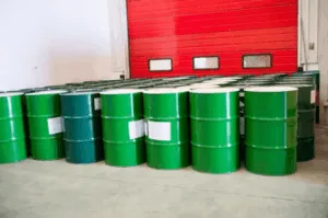 Fusti industriali verdi impilati in magazzino.