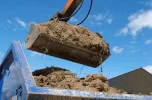 Escavatore scarica terra in un camion