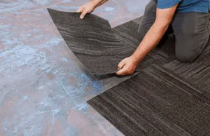 Posa di piastrelle in moquette su pavimento